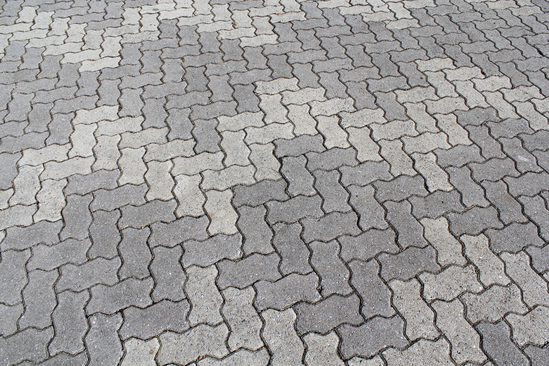 Close up of interlocking grey bricks forming a pattern in a pavement